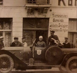 an old photo of a man driving a car