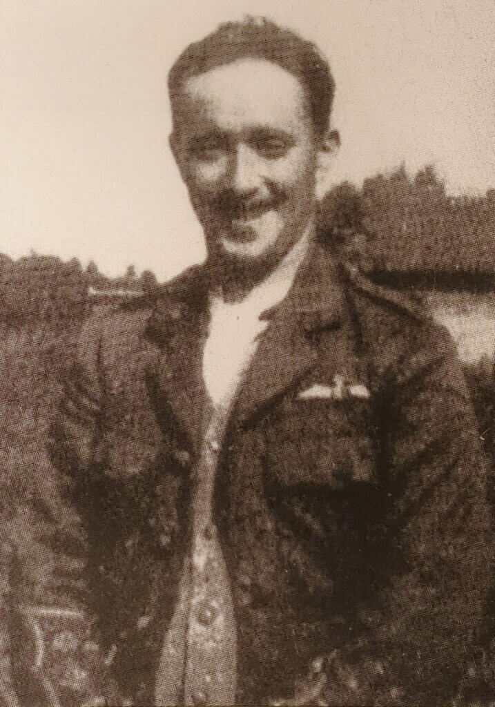 a black and white photo of a man wearing a jacket and tie