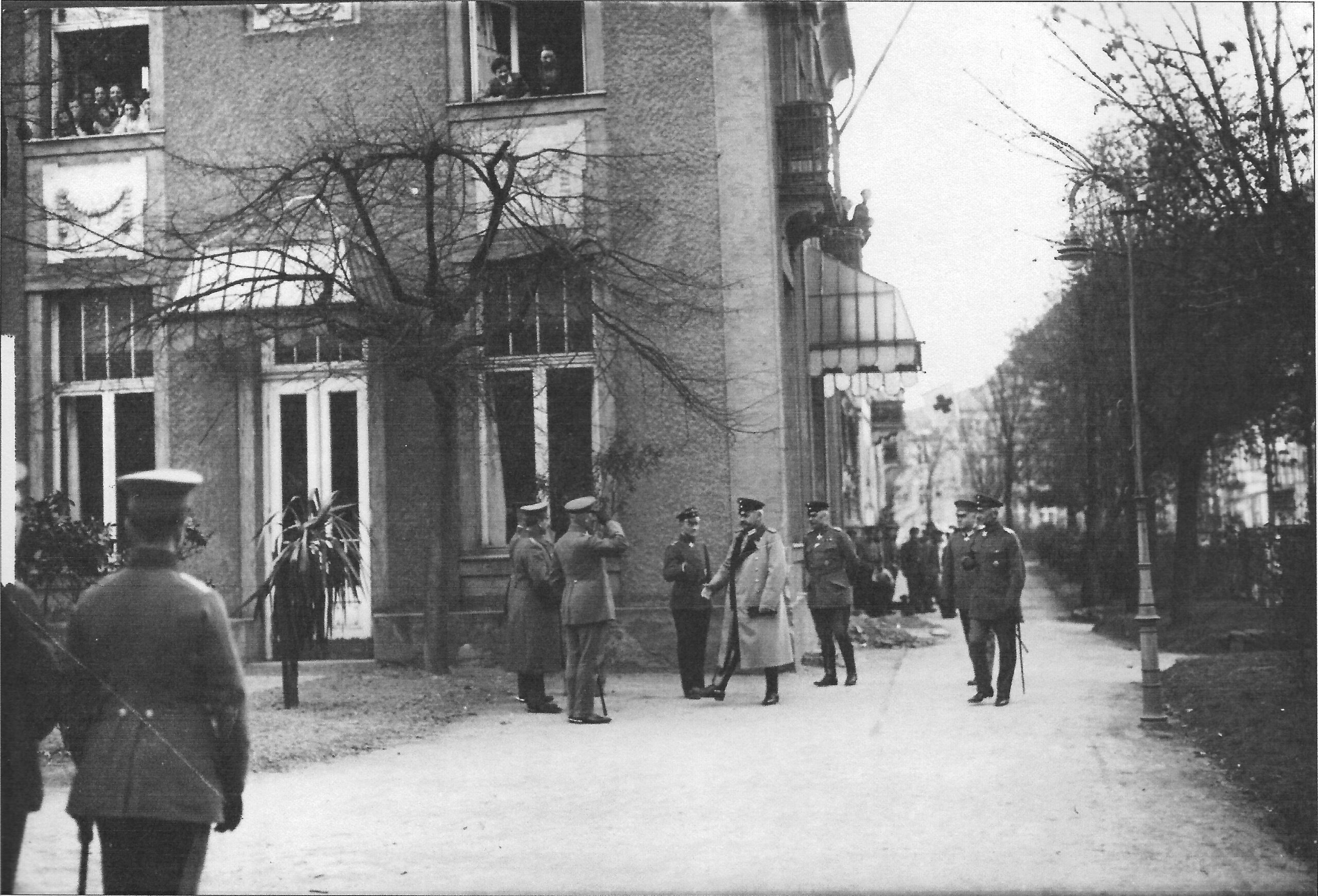 a group of people walking down a street next to a tall building